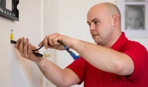 Technician hiding cables in London Flat